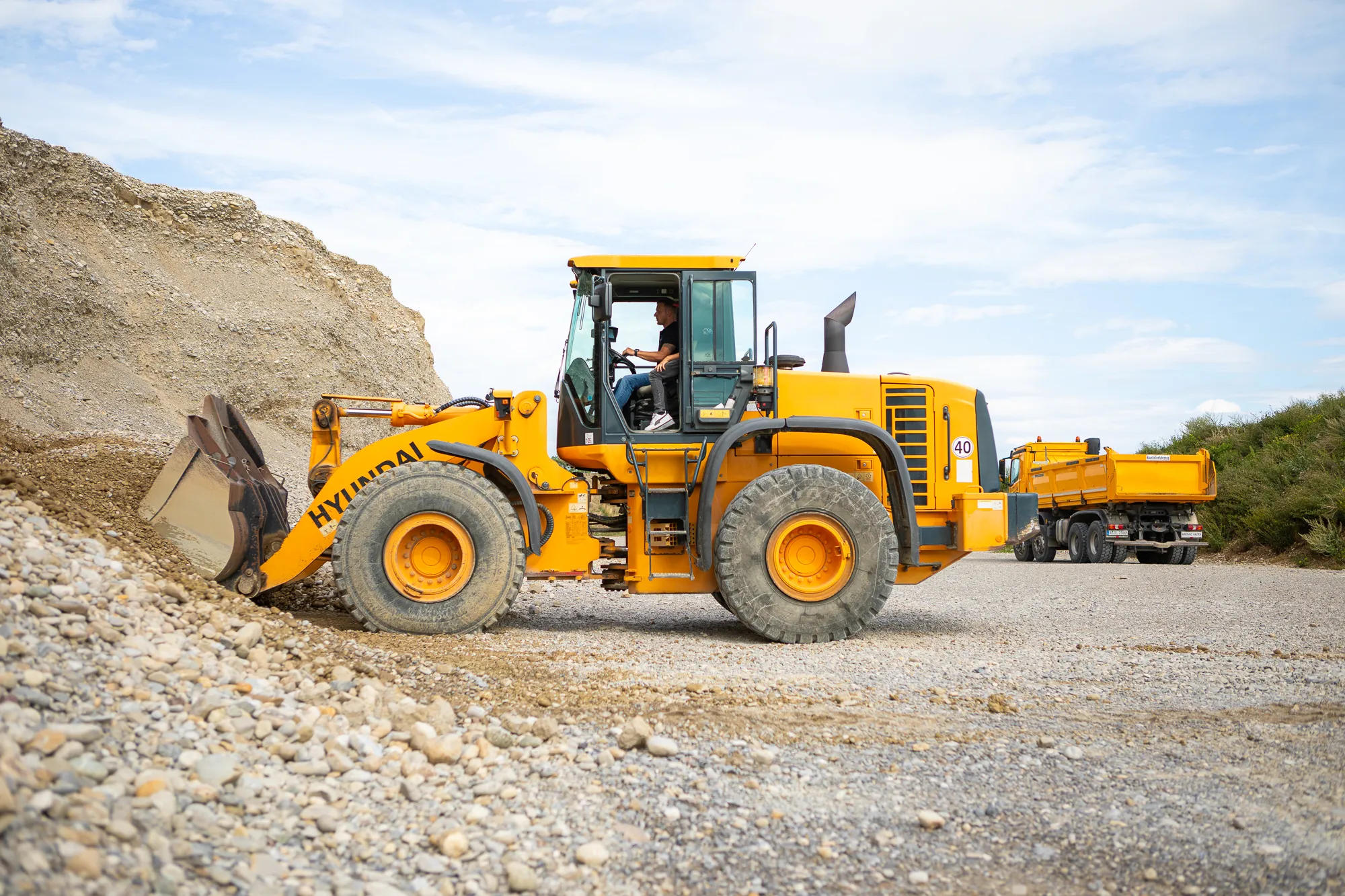 Radlader im Einsatz in der Kiesgrube – moderner Maschinenpark und abwechslungsreiche Aufgaben für Baggerfahrer im Bereich Erdbau und Baustoffverladung.